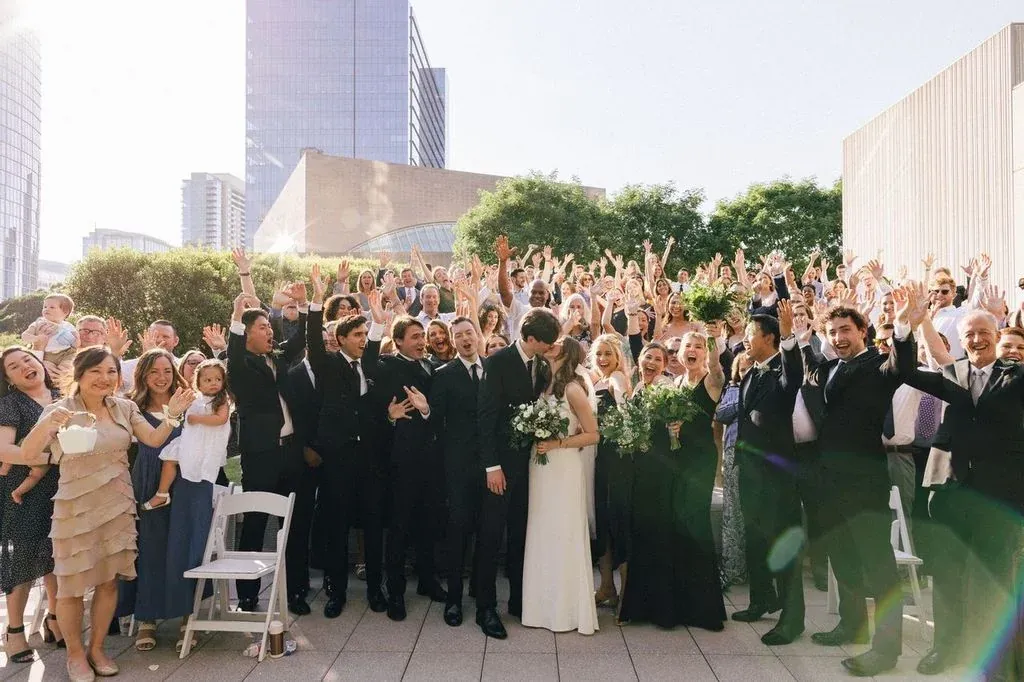 Guests gathered on the rooftop terrace with the Downtown Dallas skyline behind
