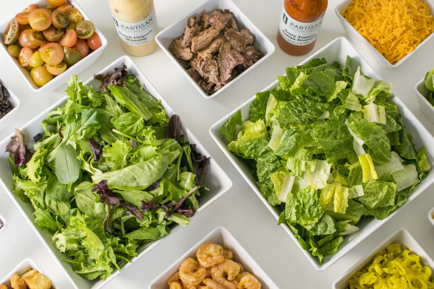 A corporate catering spread of salads, sandwiches and sides